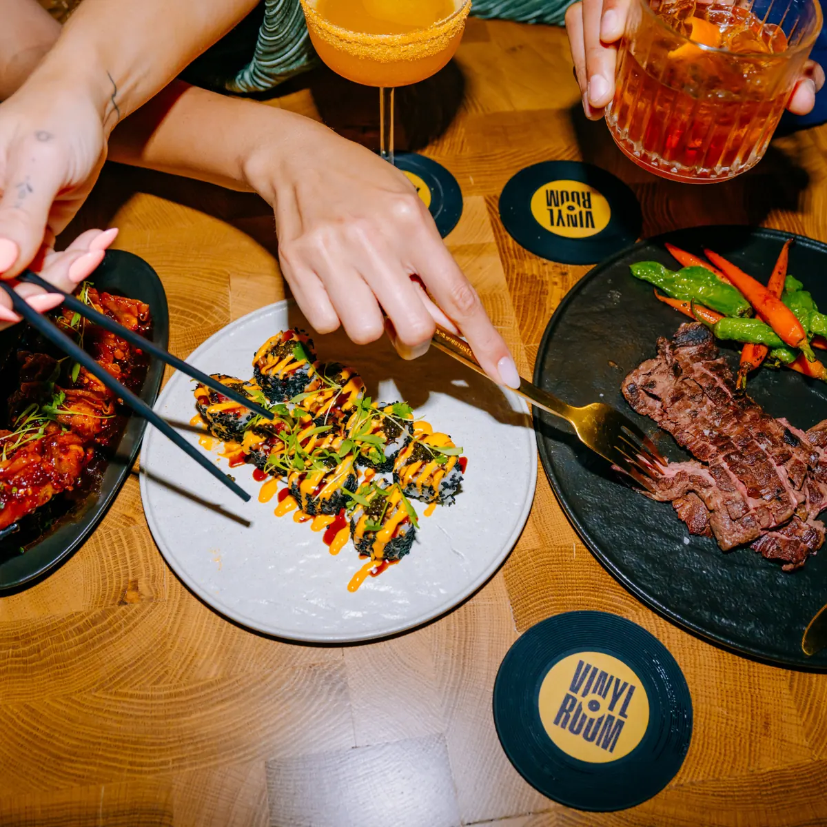 Vinyl Room Las Vegas cocktails and shared plates on a branded table